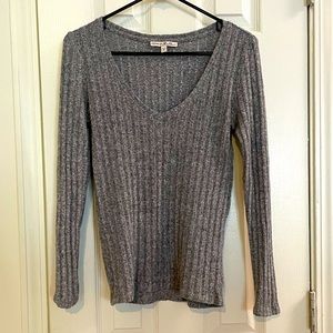 Fitted, long-sleeved grey v-neck sweater.